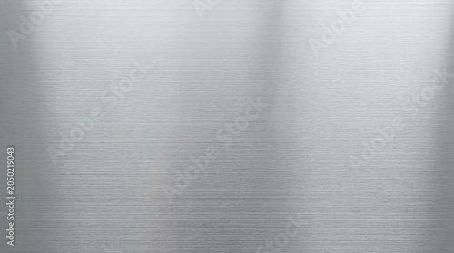 Bright silver brushed stainless steel texture background with soft light reflection and horizontal grain pattern
