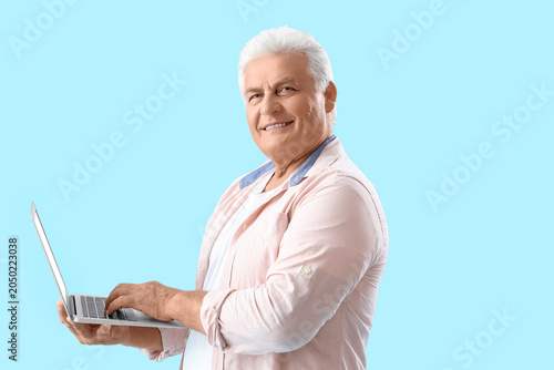 Senior man using laptop on ...
