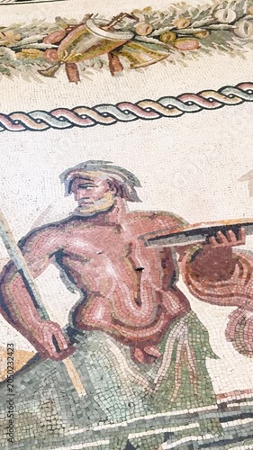 Close-up ancient Roman mosaic with warrior figure and decorative border