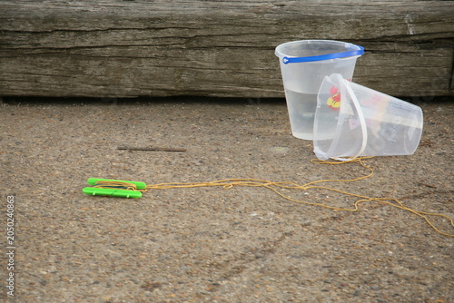 Clear buckets with a fishing line on the harbor wall