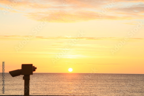 Sunrise with a telescope in the foreground