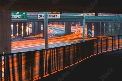 Traffic flows in Gothenburg city with bright lights and signs during the evening hours on a busy road