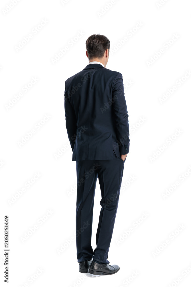Obraz premium Back view of elegant man standing with hands in pockets