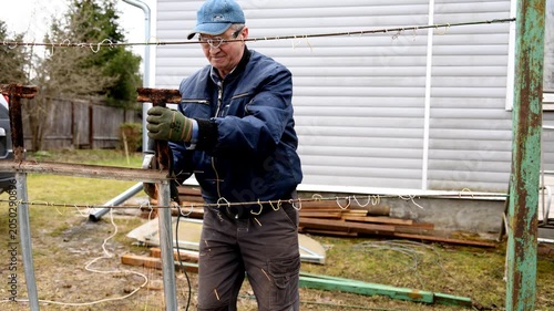 A construction worker cuts metal into pieces. A worker cuts metal into pieces with a special saw.