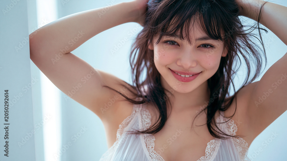 Fototapeta premium Smiling young woman in white lingerie posing indoors with natural light