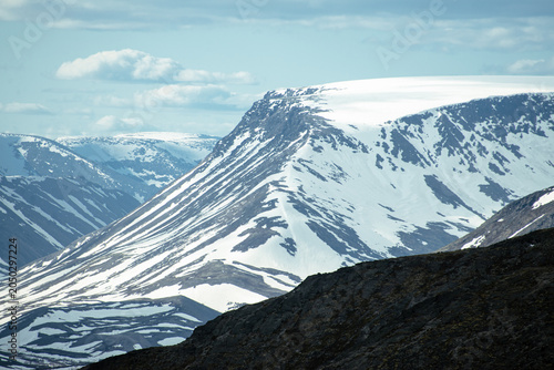 Bild auf Leinwand Snow-covered mountain ridge with rocky foreground