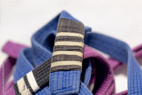 Brazilian Jiu-Jitsu Blue Belt with Four Stripes and Purple Belt on White Background