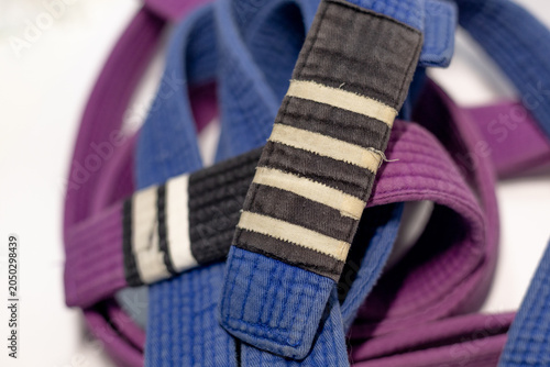 Brazilian Jiu-Jitsu Blue Belt with Four Stripes and Purple Belt on White Background