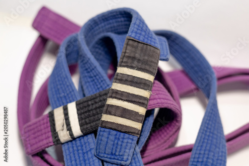 Brazilian Jiu-Jitsu Blue Belt with Four Stripes and Purple Belt on White Background