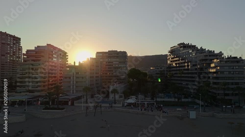 Calpe beachfront apartment buildings at sunrise with golden sun between towers Spain