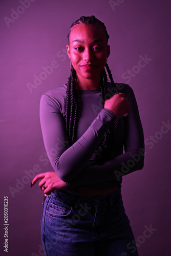 Young woman with braids posing in purple light