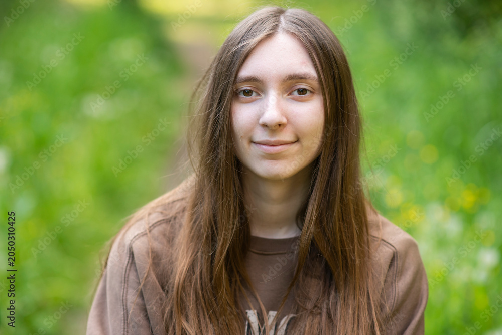 Naklejka premium Young adult woman smiling outdoors close up portrait