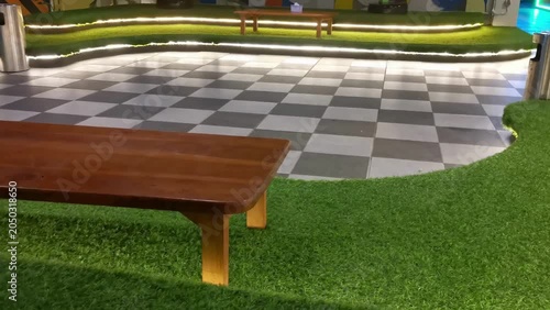 Modern Lounge Area with Green Artificial Turf, Checkered Floor, and Ambient LED Lighting