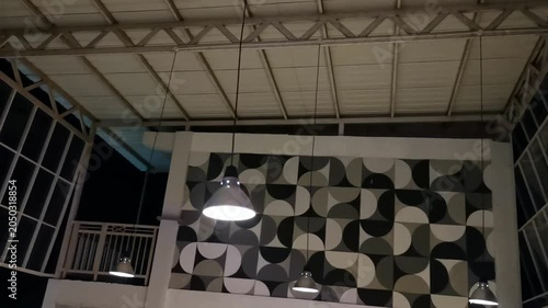 Modern Cafe Interior with Geometric Wall Decor and Industrial Pendant Lights at Night