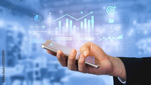 Fotografía Professional hand holding smartphone with financial graphs and data analysis in modern business environment, illustrating digital technology and innovation Haptic