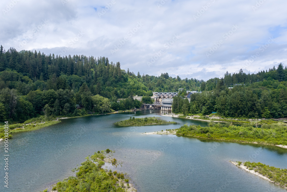 Fototapeta premium Hydroelectric Dam and River Surrounded by Lush Evergreen Forest Landscape Near Mission, BC, Canada