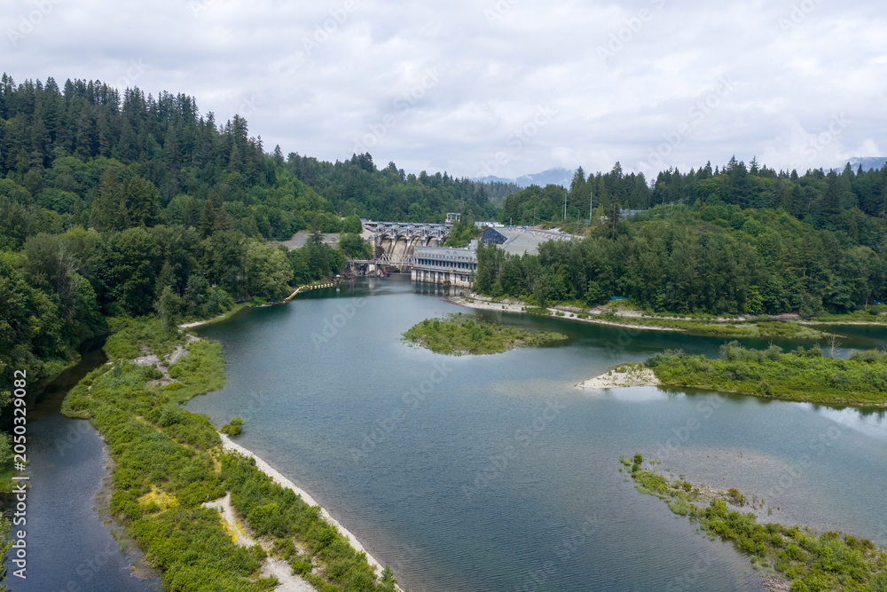 Fototapeta premium Hydroelectric Dam and River Surrounded by Forested Hills Near Mission, BC, Canada