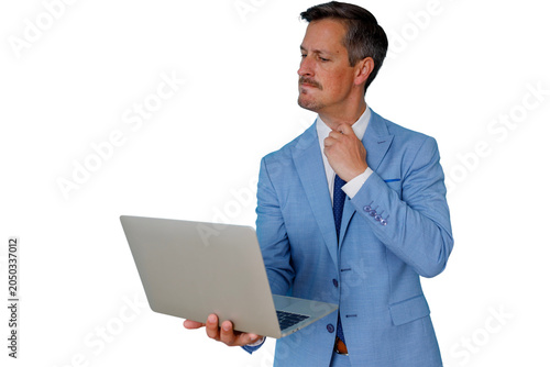 Quadro em tela Businessman in a blue suit looking frustrated, loosening his tie, holding a laptop