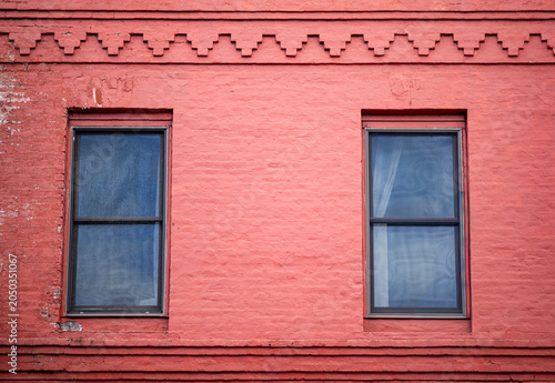 Faded Red Old Building with Brick Facade and Windows.