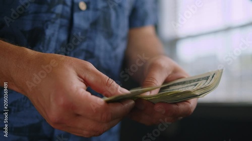 Hands skillfully sort through crisp bills in a charming cafe, sunlight streaming through the windows, creating a warm and inviting atmosphere for the onlooker