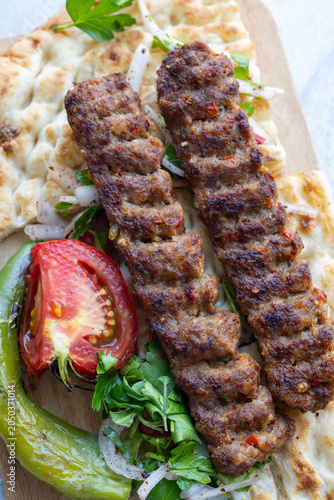 traditional Turkish Adana kebab served with grilled tomatoes and green peppers 