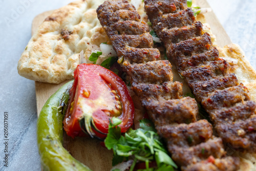 traditional Turkish Adana kebab served with grilled tomatoes and green peppers 