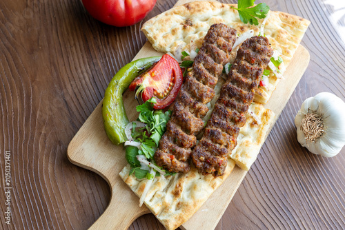 traditional Turkish Adana kebab served with grilled tomatoes and green peppers 