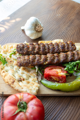 traditional Turkish Adana kebab served with grilled tomatoes and green peppers 