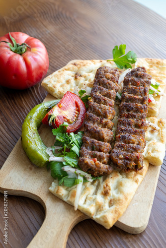 traditional Turkish Adana kebab served with grilled tomatoes and green peppers 