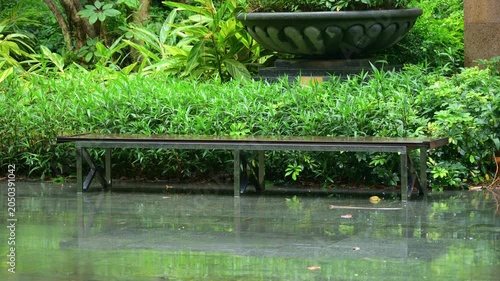Bench in the residential community garden on a rainy day video with sound