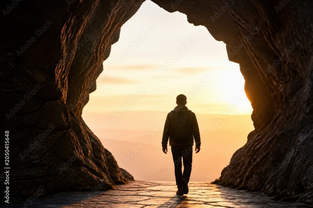 Fototapeta premium Business leader walking from cave into sunrise symbolizing strategy and breakthrough