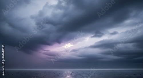 Dramatic dark storm clouds gathering over the calm ocean surface at twilight.