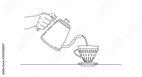 Photos Hand pouring water from kettle into coffee dripper.