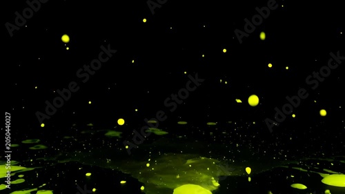 Bright yellow paint splash on black background with abstract yellow droplet motion and dynamic liquid splatter