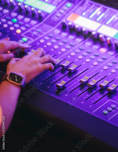 Lighting engineer operator working on mixing console workplace during live event concert on stage show broadcast, light mixer controller panel, sound technician workplace with professional equipment