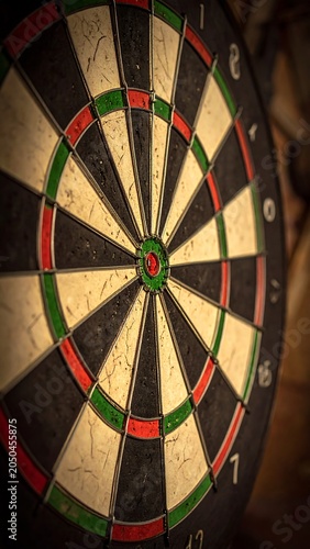 A close-up of a dartboard with a worn and scratched surface
