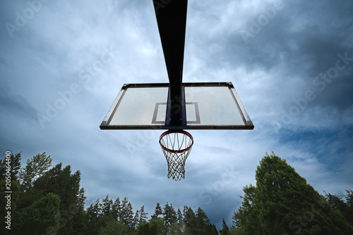 Basketball net and backboard against cloudy sky
