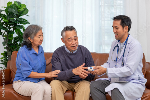 Fotografi A male doctor or caregiver using fingertip pulse oximeter to check blood oxygen