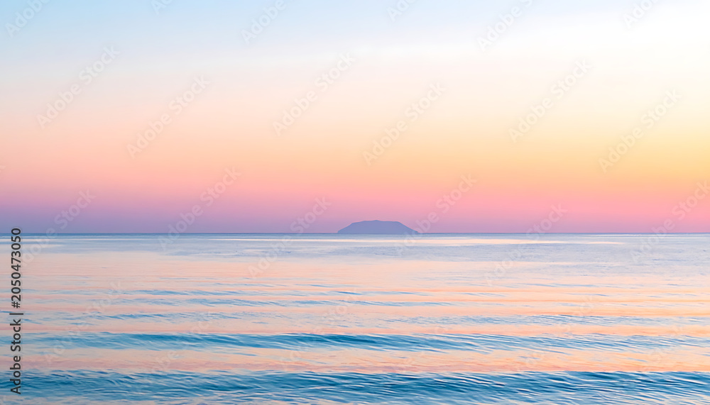 Naklejka premium Serene ocean sunset with soft pastel sky, calm water, and distant island, peaceful seascape, travel and vacation concept