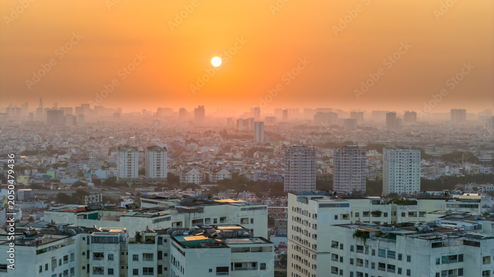 Fototapeta premium Aerial view of Saigon cityscape at morning with misty sky in Southern Vietnam. Urban development texture, transport infrastructure and green parks