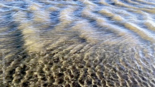 Slow motion of water flowing in the shallows with big and small waves