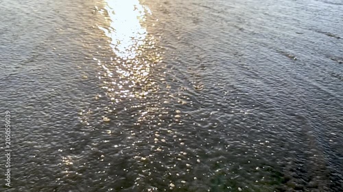Slow motion of water flowing with a sun glare
