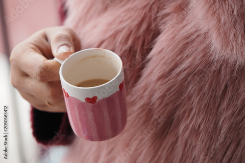 Bild auf Leinwand Enjoying coffee in a pink cup during a casual moment