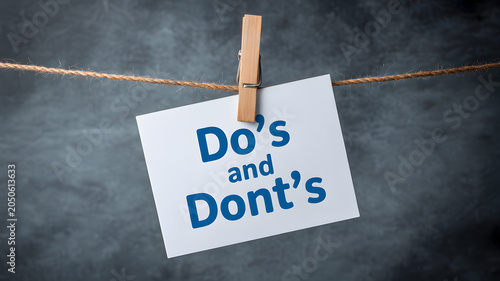 A white card with do's and don'ts text hanging on a rope with a clothespin