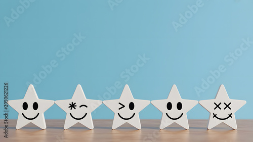 A row of five white stars with different facial expressions on a wooden surface