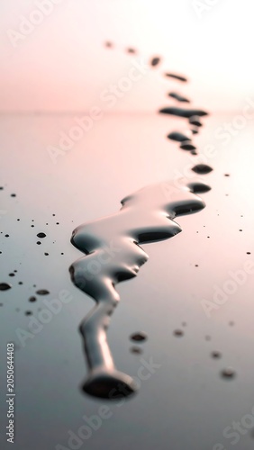 Abstract close up of liquid dripping on a reflective surface with copy space