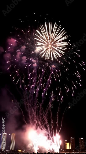Intense red fireworks display with thick smoke near horizon.