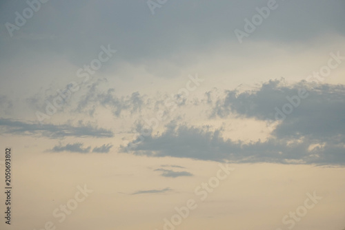 Pale evening sky with wispy grey clouds during sunset. Minimalist overcast cloudscape, calm and serene nature