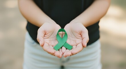 Green Awareness Ribbon Held in Hands, Symbolizing Support, Hope, Mental Health, and Causes