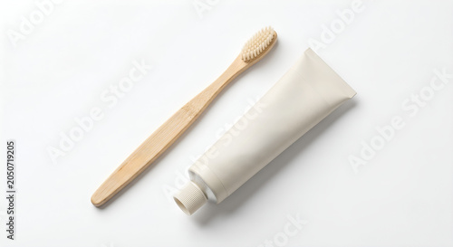 Natural bamboo toothbrush and blank toothpaste tube mockup isolated on a white background
